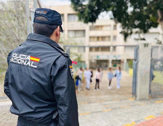 Archivo - Agente de la Policía Nacional, a las puertas de un centro educativo. (Foto de archivo).