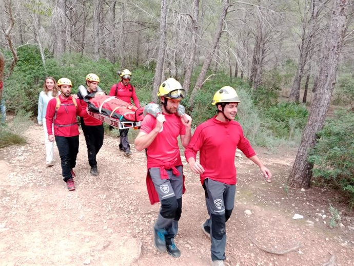 Efectivos de bomberos trasladan a la mujer en camilla.