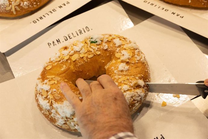 Archivo - Un pastelero parte un roscón en la pastelería Pan Delirio