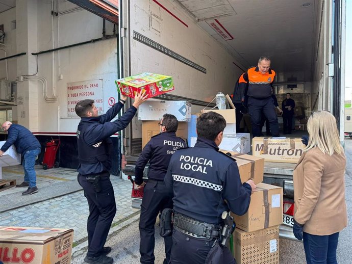 Efectivos de la Policía Local de Cádiz cargan juguetes en un camión con destino Benetússer, en Valencia