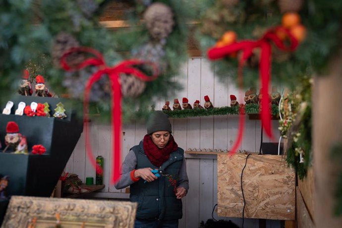 Una persona atiende en un puesto navideño en la Fira de Santa Llúcia de Barcelona