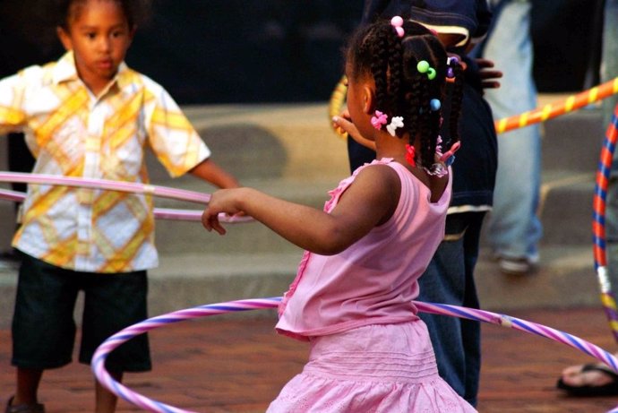 Niños jugando con hula hoops.