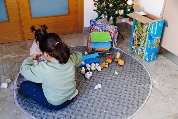 Una niña abre sus regalos de Navidad.