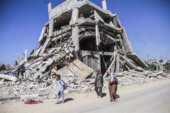 Archivo - Palestinos junto a un edificio destruido por los ataques del Ejército de Israel contra Yabalia, en el norte de la Franja de Gaza (archivo)