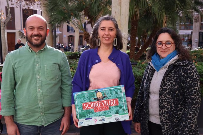 Los regidores de MÉS per Palma Miquel Àngel Contreras, Neus Truyol y Kika Coll regalan el juego 'Sobreviure a Palma' a Martínez.