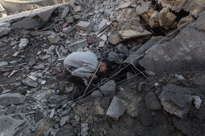 Un joven palestino inspecciona los escombros de un edificio destruido en Deir el Balá