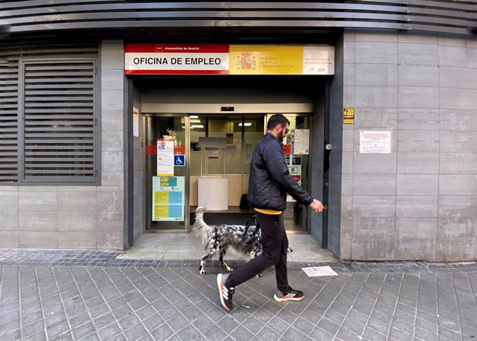 Archivo - Un hombre pasa con su perro por la oficina de empleo de Acacias