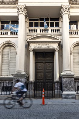 Archivo - November 22, 2024, Buenos Aires, Argentina: Nov 22, 2024 - Buenos Aires, Argentina - Entrance gate to the Central Bank of the Argentine Republic, a traffic cone can be seen in front and a man on a bicycle passing quickly. The Argentine economy i