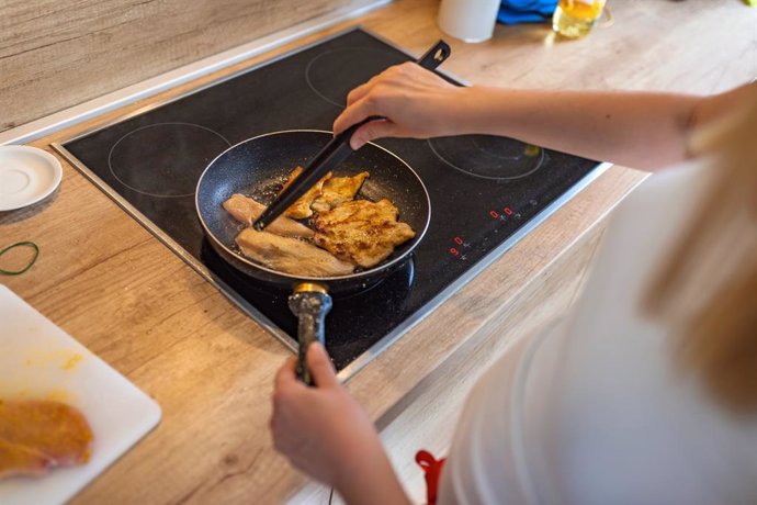 Archivo - Mujer cocinando pollo