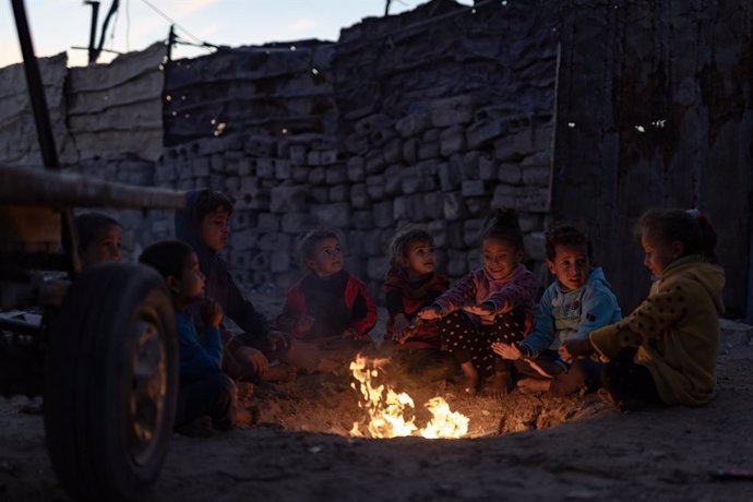 December 9, 2024, Khan Yunis, Gaza Strip: Palestinian children light a fire to escape the cold of the tents in one of the displacement camps in Khan Yunis, southern Gaza Strip.