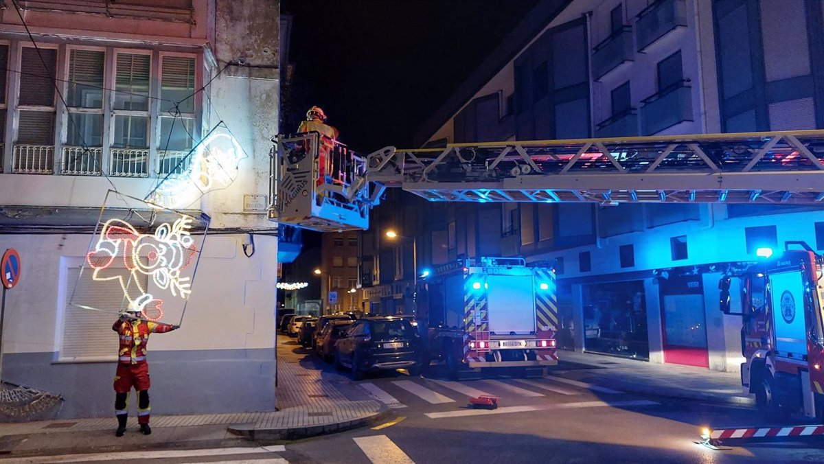 Bomberos retiran el alumbrado navideño descolgado de una calle de Santoña por el viento