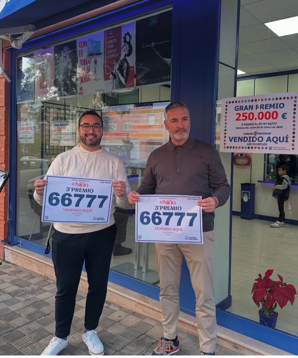 Jorge García y "Arzu" posan ante su administración de lotería de Montequinto para festejar su tercer premio del sorteo de El Niño