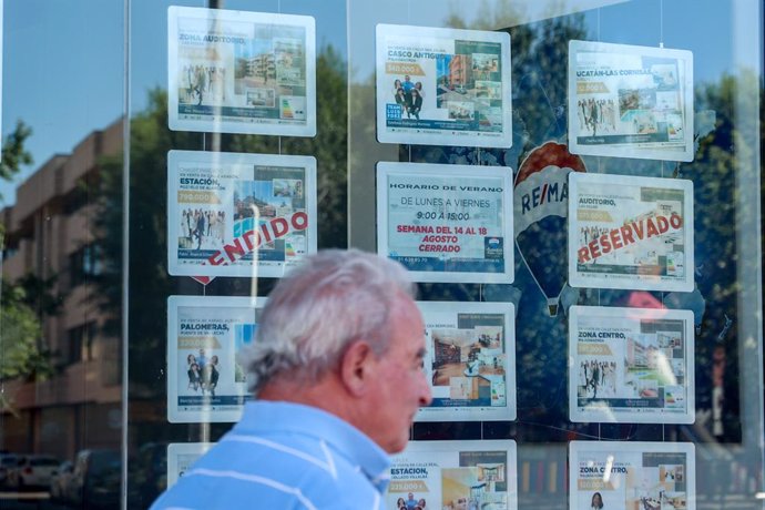 Archivo - Un hombre camina frente a un escaparate de anuncios de viviendas, a 4 de agosto de 2023, en Madrid (España). La compraventa de vivienda en España disminuye un 6,4% interanual por el retroceso de las operaciones sobre los inmuebles usados, según 