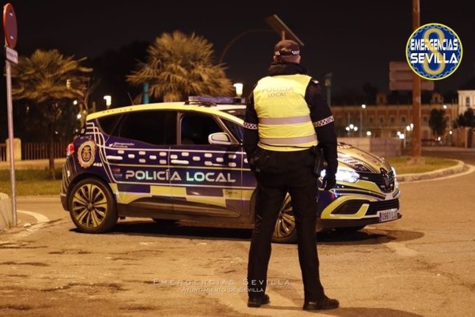 Archivo - Agente ante un vehículo de la Policía Local de Sevilla