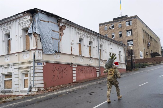 Un militar ucraniano carga un árbol de Navidad en Kupiansk