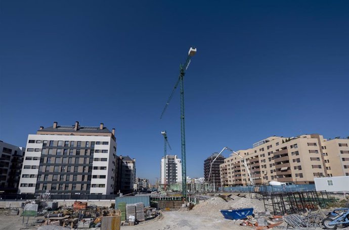 Archivo - Grúas en una zona de construcción de edificios, 