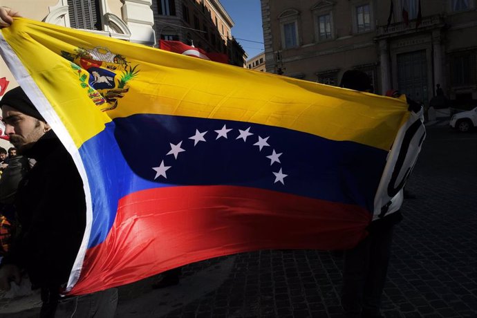 Archivo - Una persona porta una bandera de Venezuela en una protesta contra el Gobierno de Maduro, en Roma.