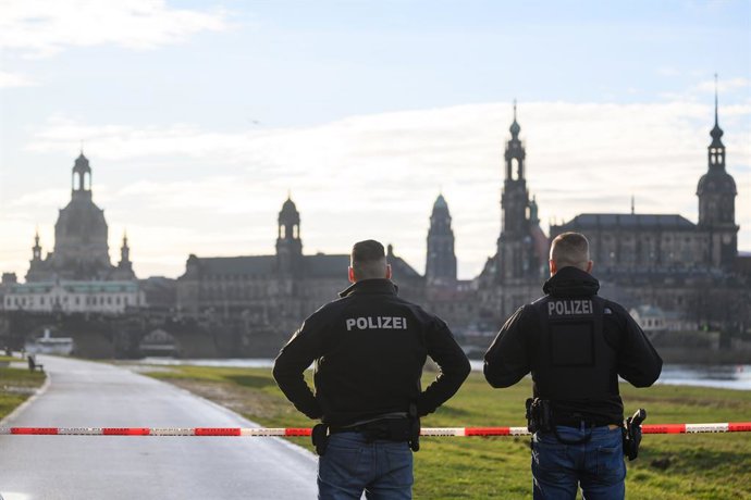 09 January 2025, Saxony, Dresden: Police officers close the Elbe cycle path opposite the Old Town during an evacuation of the city center. A World War II bomb was found the day before on the partially collapsed Carola Bridge in Dresden; around 10,000 peop