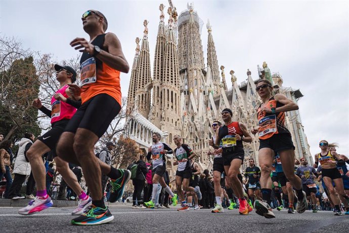 Archivo - Varios corredores pasan junto a la Sagrada Familia durante la Zurich Marató de Barcelona 2024