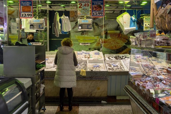 Archivo - Una mujer compra en una pescadería en un mercado en Madrid (España). 