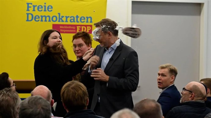 Una joven arroja espuma a la cara del candidato del Partido Liberal de Alemania, Christian Lindner, durante un acto de campaña en Greifswald, en el noroeste del país.