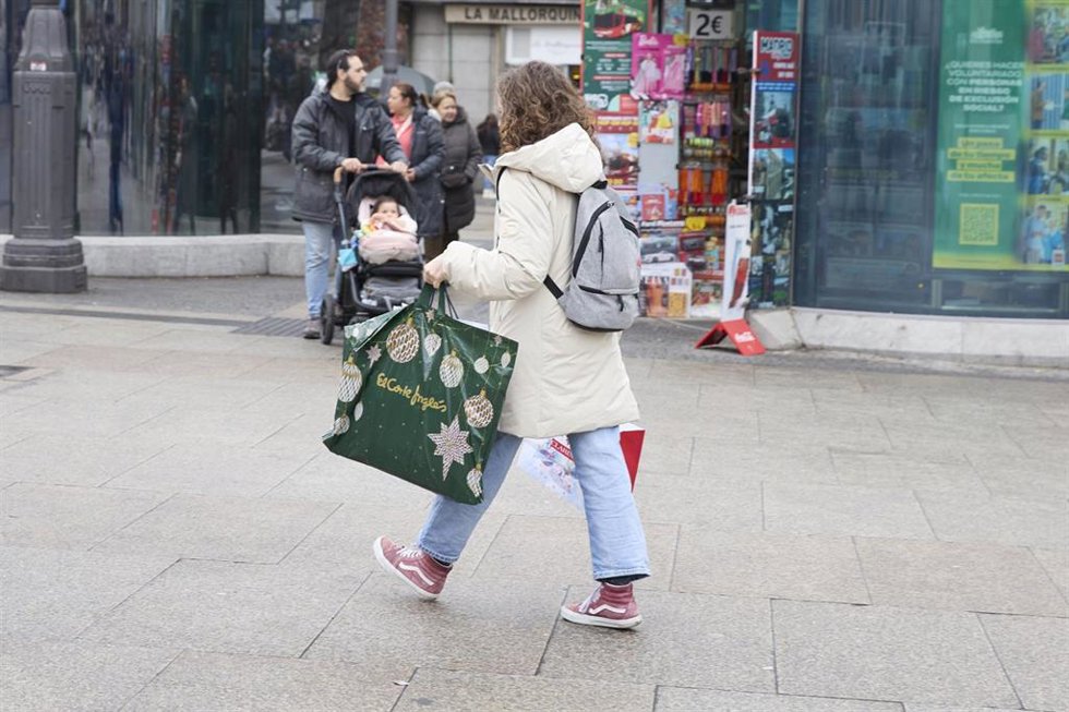 Una mujer con una bolsa tras comprar .