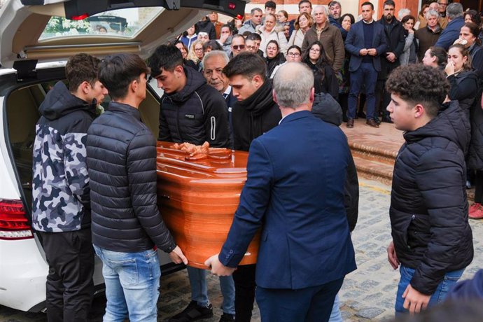 Amigos del fallecido descargan el féretro con sus restos antes del funeral