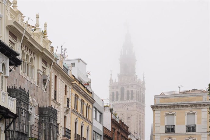 La giralda de Sevilla rodeada de una intensa niebla. Imagen de archivo. 