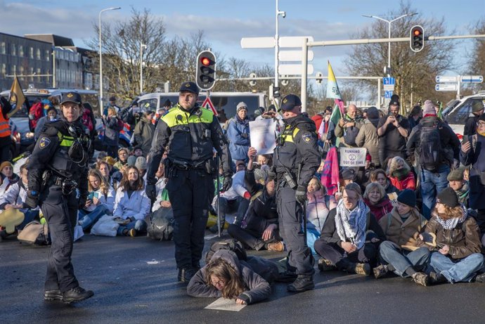 January 11, 2025, The Hague, South Holland, Netherlands: Dutch police stand over an activist shortly before arresting them. On January 11, 2025, in nearly freezing weather, climate activists attempted to block the A12 highway in The Hague, the Netherlands