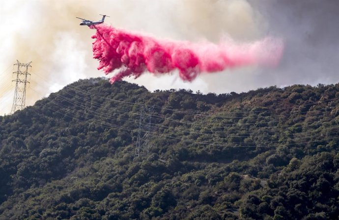 January 11, 2025 - Los Angeles, California, USA - A plane drops Phos-Chek fire retardant into Mandeville Canyon, one of the neighborhoods threatened by the Palisades Fire, which spread north and east overnight. According to the Los Angeles Fire Departme
