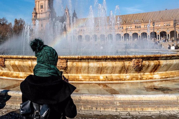 Archivo - Personas abrigadas por los alrededores de la Plaza de España,  en un día frío y el soleado a la vez, a 27 de diciembre del 2023 en Sevilla (Andalucía, España). 