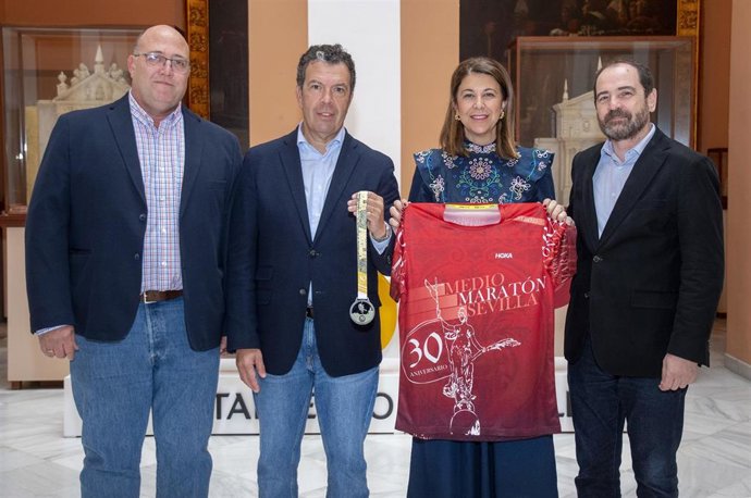 La delegada de Deportes y el coordinador de este área municipal portan la medalla y la camiseta del Medio Maratón de la ciudad, en un acto celebrado en el Ayuntamiento.