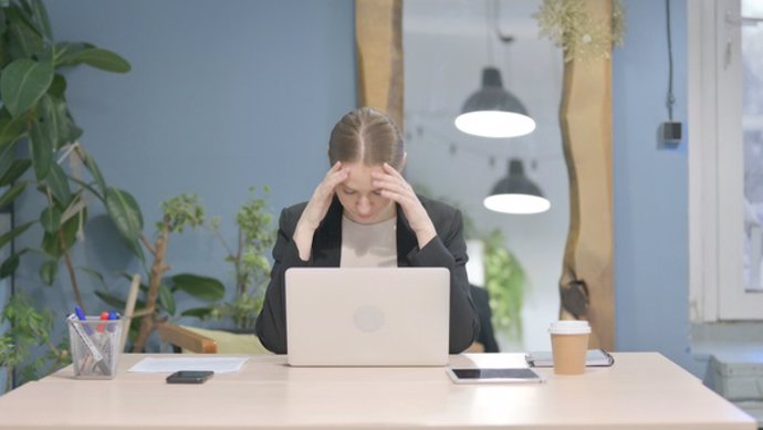 Archivo - Young Businesswoman Reacting to Loss While Working in Office