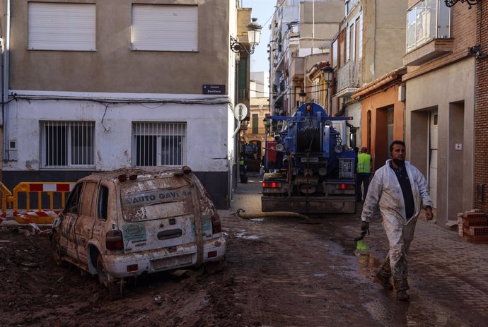 Archivo - Arxiu - Un cotxe destrossat per la dana en un carrer cobert de fang