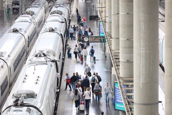 Archivo - Viajeros con maletas en uno de los andenes de la estación Almudena Grandes-Atocha Cercanías