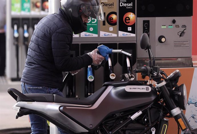 Archivo - Archivo.- Un hombre inyecta carburante en una moto, a 28 de octubre de 2021, en Madrid (España). 