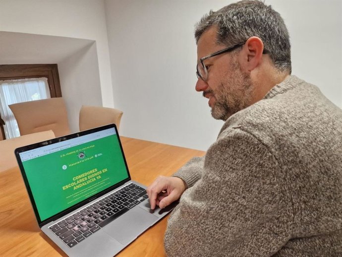 El portavoz de Adelante Andalucía, José Ignacio García, este miércoles en un ordenador portátil accediendo al portal donde recogerán quejas sobre los comedores escolares.