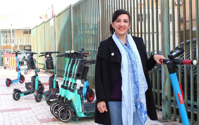 La portavoz de Con Málaga en el Ayuntamiento de la capital, Toni Morillas, junto a patinetes estacionados en la vía pública.