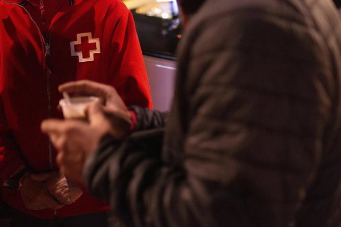 Archivo - Personal de Cruz Roja atiende a una persona sin hogar, en una imagen de archivo.