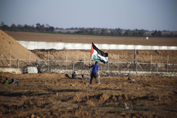 Archivo - Imagen de archivo de un hombre con una bandera palestina en la Franja de Gaza