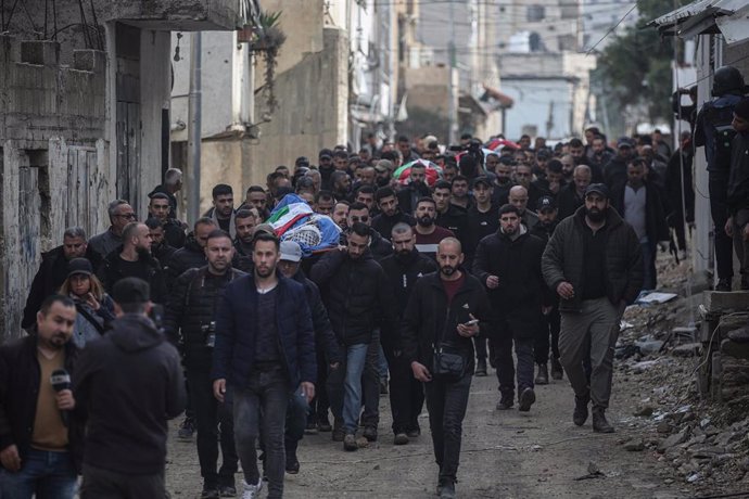 Un grupo de palestinos transporta los cuerpos de los muertos en un ataque israelí en el campamento de refugiados de Yenín (Cisjordania)