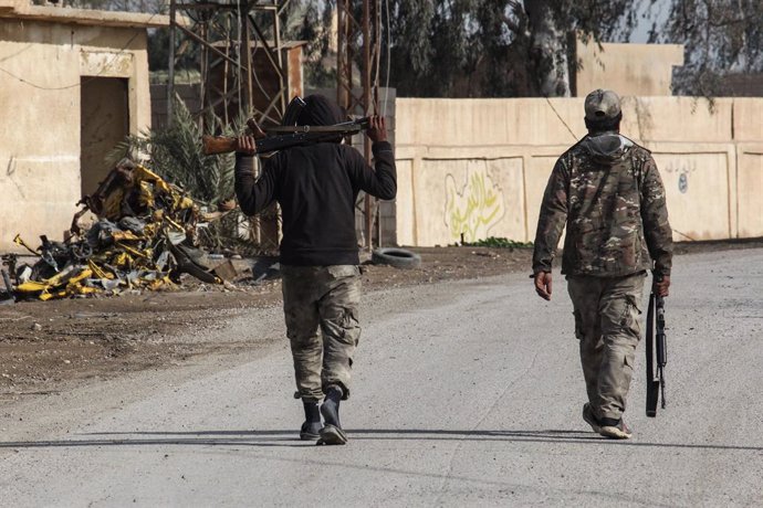 Archivo - 16 February 2019, Syria, Hajin: Two fighters of the Syrian Democratic Forces (SDF), a US-allied Kurdish-led rebel group, patrol in the streets of the recently liberated town of Hajin. SDF officials have said the extremists are clinging to an are