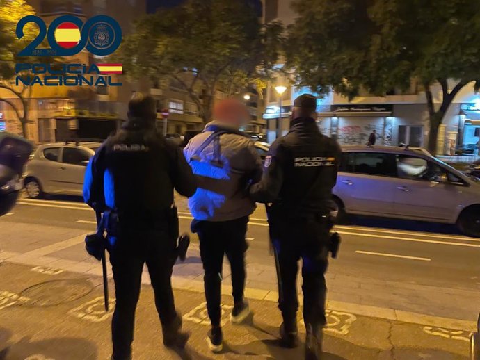 Agentes de la Policía Nacional con el detenido por vender droga en patinete.