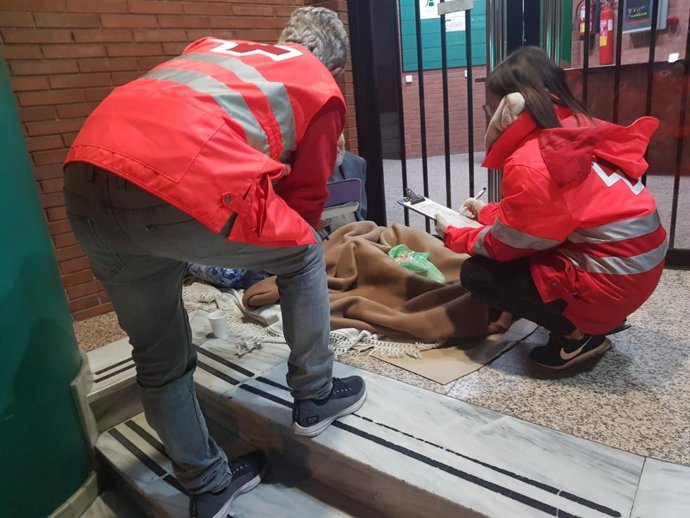 Voluntarios de la Cruz Roja atienden a una persona sin hogar durante una intervención de la Unidad de Emergencia Social (UES) en Almería.