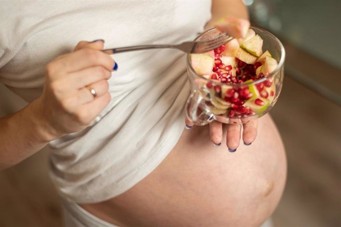 Imagen de archivo de una mujer comiendo saludable durante el embarazo.