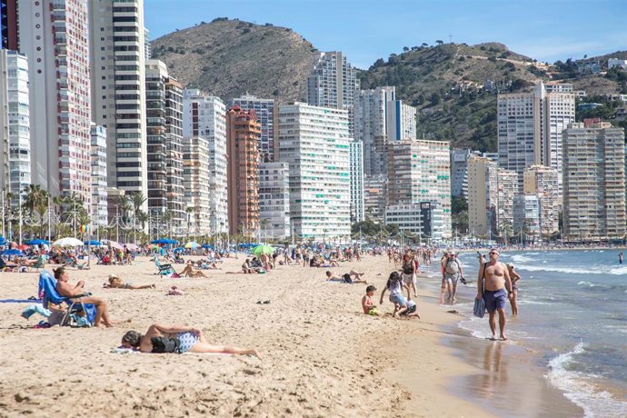Archivo - Numerosas personas toman el sol en la playa de Poniente, a 11 de marzo de 2023, en Benidorm