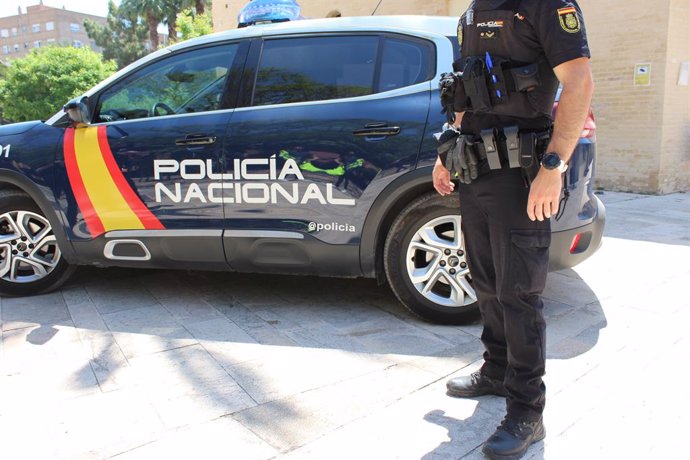 Archivo - Un agent i un vehicle de la Policia Nacional 