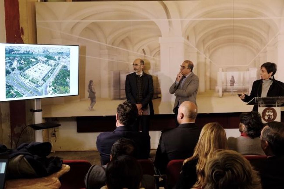 El rector de la US observa los detalles del proyecto museístico en un vídeo, con una recreación virtual del mismo en el fondo.