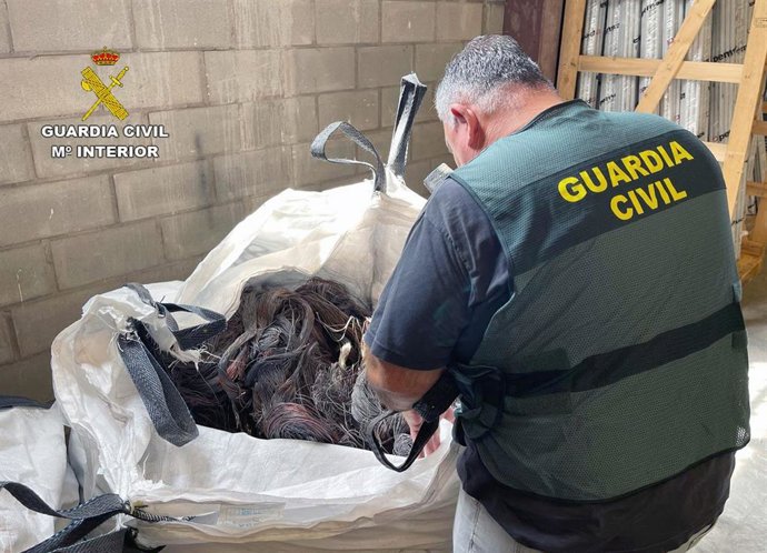 Un agente de la Guardia Civil, con material recuperado en la operación