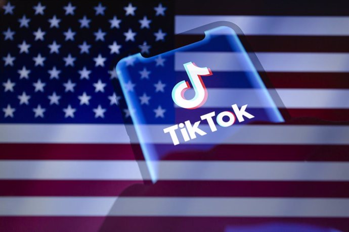 January 17, 2025, Asuncion, Paraguay: Hands hold a smartphone displaying the TikTok logo backdropped by cropped flag of the United States. The Supreme Court of the United States on Friday has ruled to uphold the law banning TikTok, the short-video app own